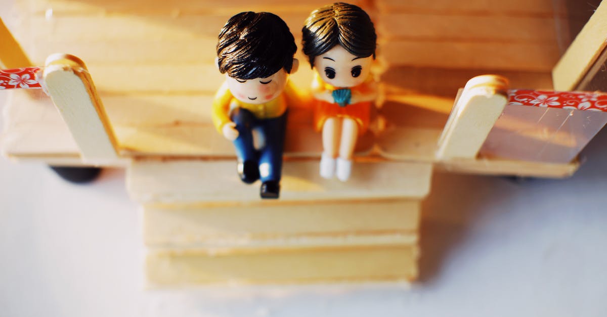 Movie about a chef couple and a little girl [closed] - From above of cute figurines of boy and girl placed on table on decorative toy building with stairs in room