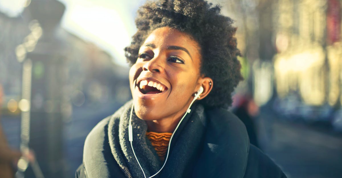 Origin of montages with incongruously happy music [closed] - Close-up Photo of a Woman Listening to Music