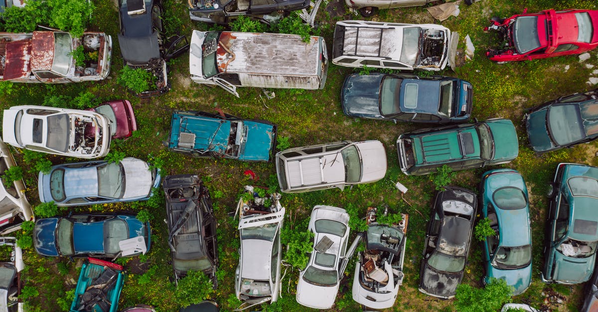 Origin of the side-view surprise car crash shot? - Car dump located on greenery in summer day