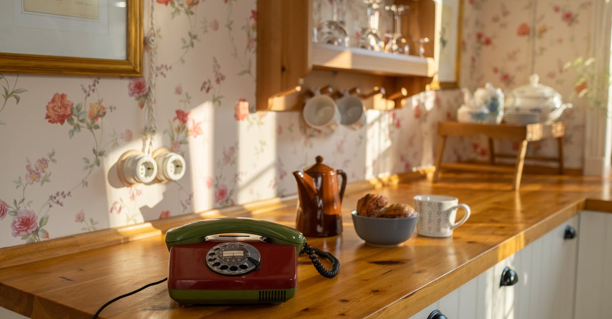 Origin: Spirits of the Past - Any ideas on who makes the 'phone call' - Retro Style Kitchen with Landline Phone on Wooden Counter