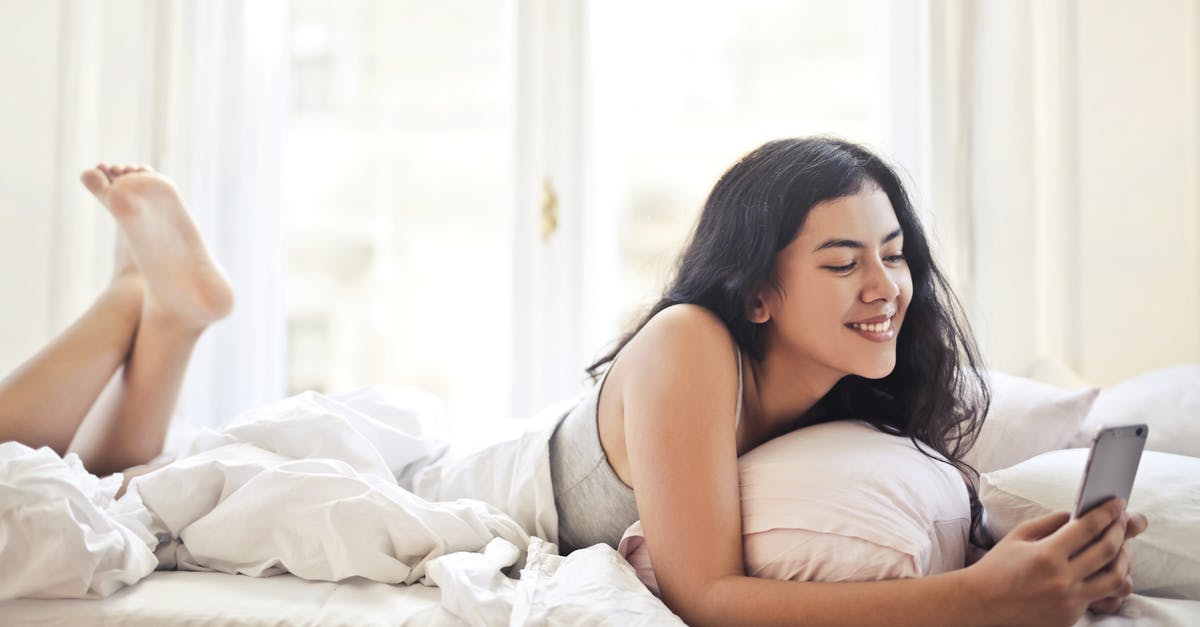 parallel time in Awake - Happy young woman browsing phone on bed