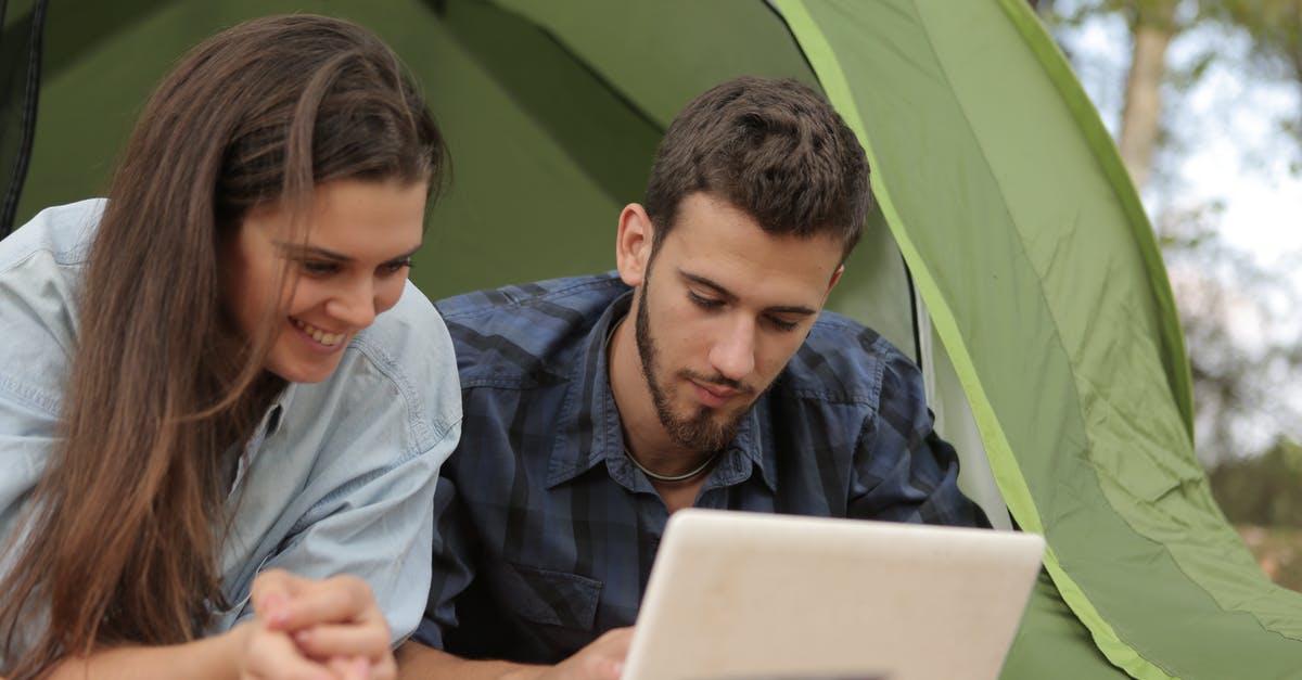 People wake on spaceship, computer lies to each person, he/she was the only survivor [closed] - Happy couple resting in tent and surfing laptop while spending time together in park