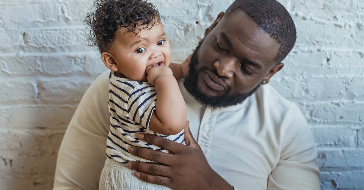 Psychological thriller in which the verse "My father was a penny" keeps recurring on a wall? [closed] - Content African American father in casual wear with cute little black toddler in arms near white wall in light room