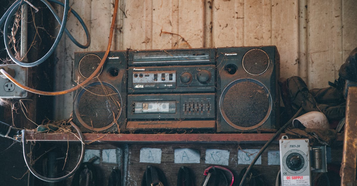 "Highlander" music used as New Line Cinema theme song - Old fashioned obsolete compact stereo system covered with dust placed on shelf near wooden wall in workshop with tools and wires