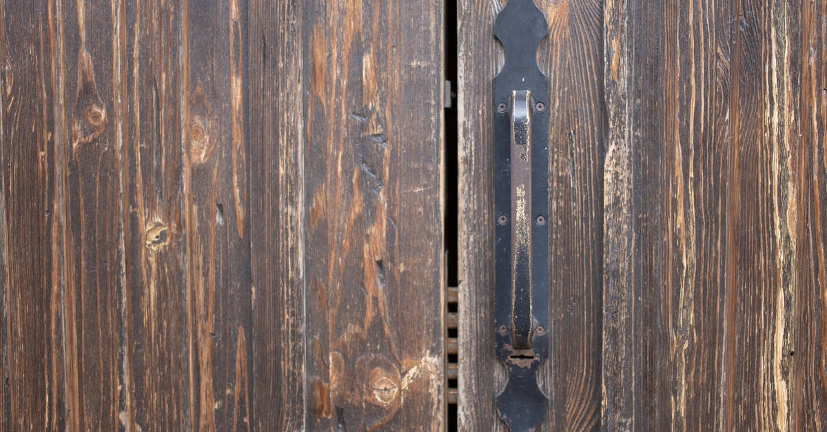 Roark Junior suffers damage to groin [closed] - Closeup of weathered old rusty brown locked wooden door with cracks on surface with aged metal handle