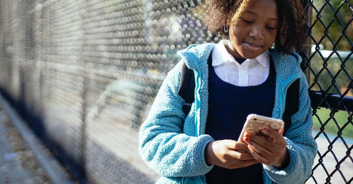 Rose's message in the season two finale of The Fall - Cheerful black schoolgirl using smartphone on street