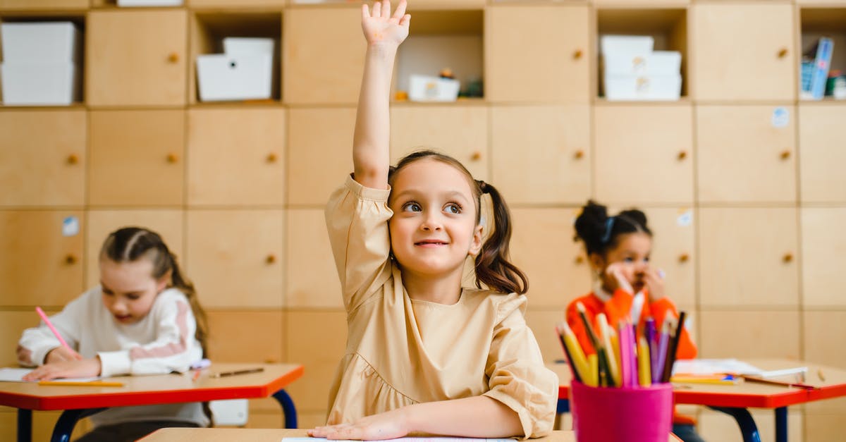 School Custodian as All-Knowing Insider - Girl Raising Hand Inside the Classroom