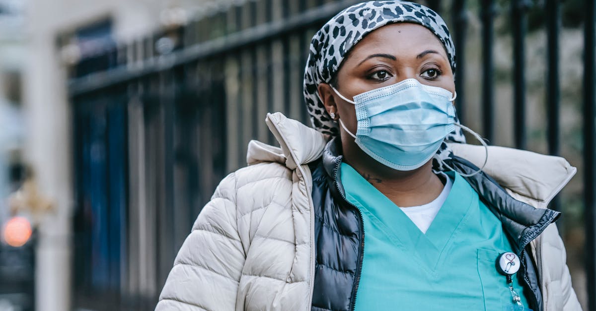 Season 5: Why does Nurse Jackie keep calling Charlie? - Thoughtful adult African American nurse wearing warm clothes and protective face mask strolling on street after duty