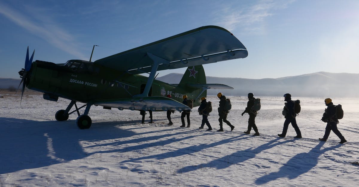 Secret Service codenames for West Wing characters - Group of military men in uniform loading into aircraft during test operation in snowy ground of airfield on sunny cold winter day