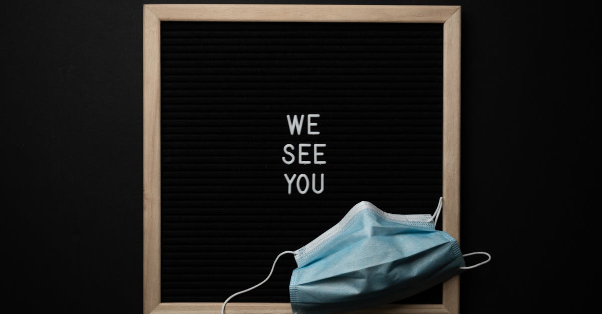 See you on the other side - From above blackboard in wooden frame with white text on center under medical mask against black background