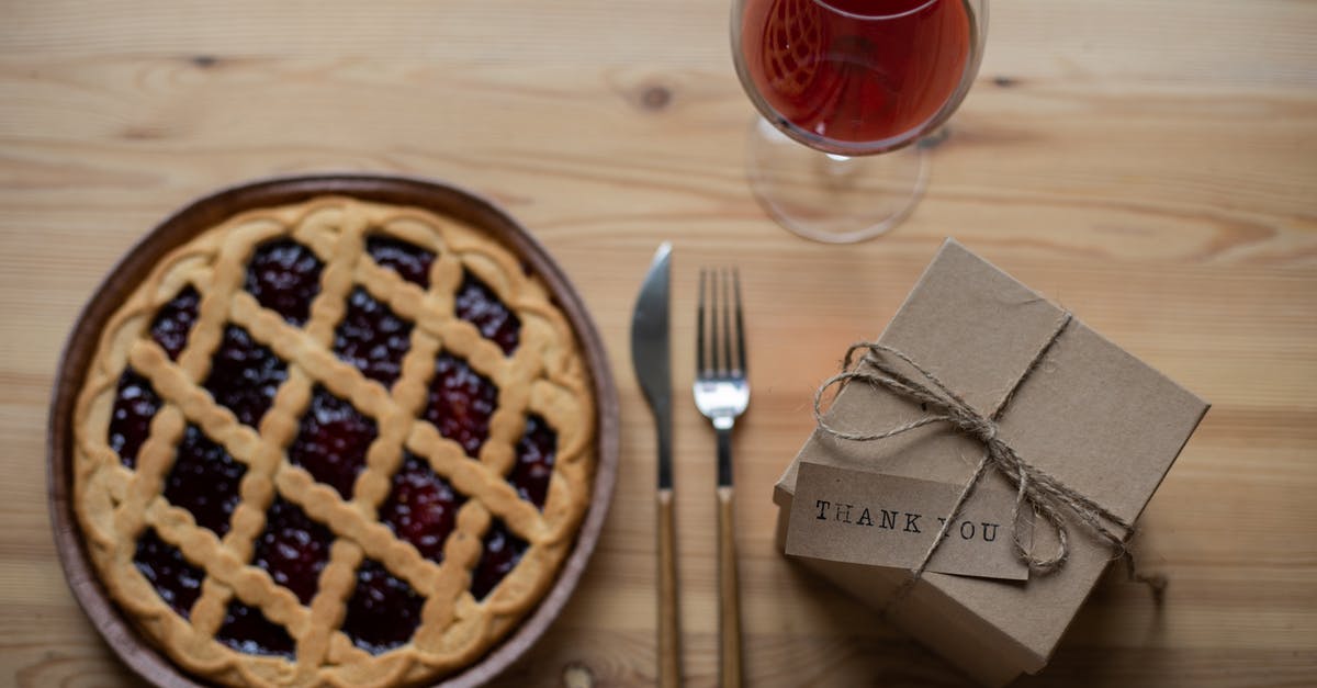 Significance of small wine glass - Delicious pie near glass of wine and gift box on table