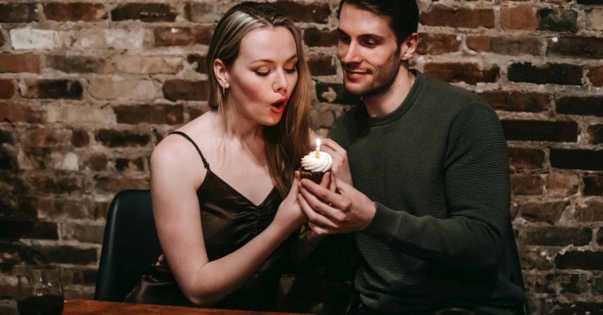 Significance of small wine glass - Couple blows in candle on birthday dessert