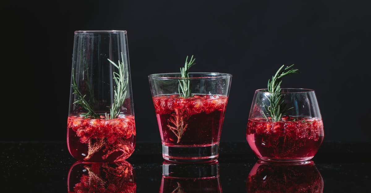 Similarity of the endings of different Sherlock Holmes adaptions - Transparent clean glasses filled with similar red cocktail with rosemary and berries on black background