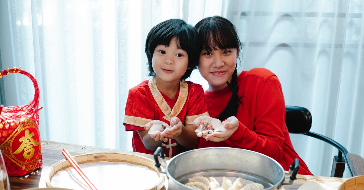 Teenage boy who witnesses the murder of his neighbor [closed] - Happy Asian teenage girl with dark hair cuddling with little brother and demonstrating traditional jiaozi dumplings during lunch preparation in kitchen