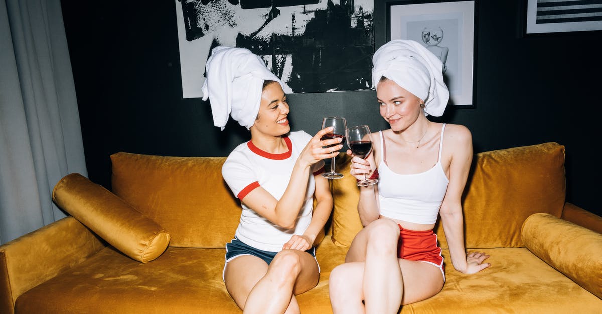 The Last Slumber Party logistic quandry - Two Young Women Sitting on a Yellow Sofa While Holding a Wine Glass With Red Wine