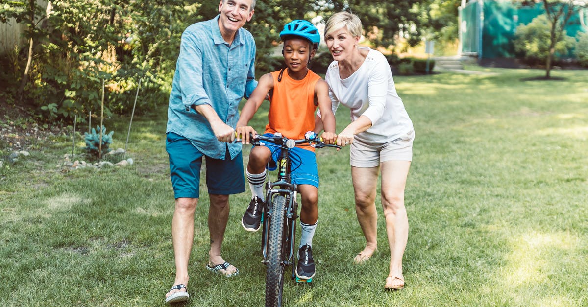 The meaning of the adopted African boy in Fargo? - Man and Woman Helping a Boy Riding a Bicycle