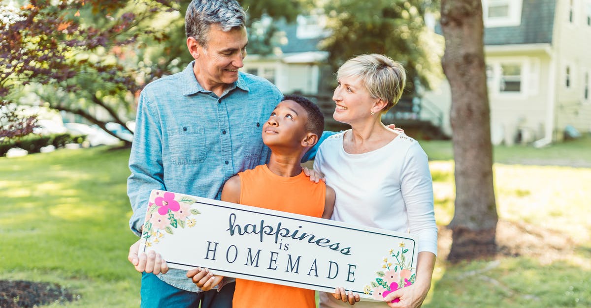 The meaning of the adopted African boy in Fargo? - A Family Holding a Happiness is Homemade Placard