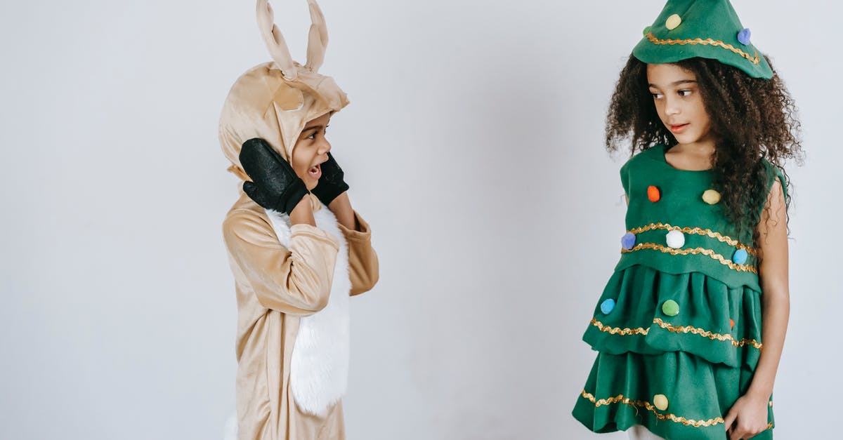 The pretending to be sister scene in JojoRabbit - Funny cute African American boy and girl in bright costumes at Christmas party on white background