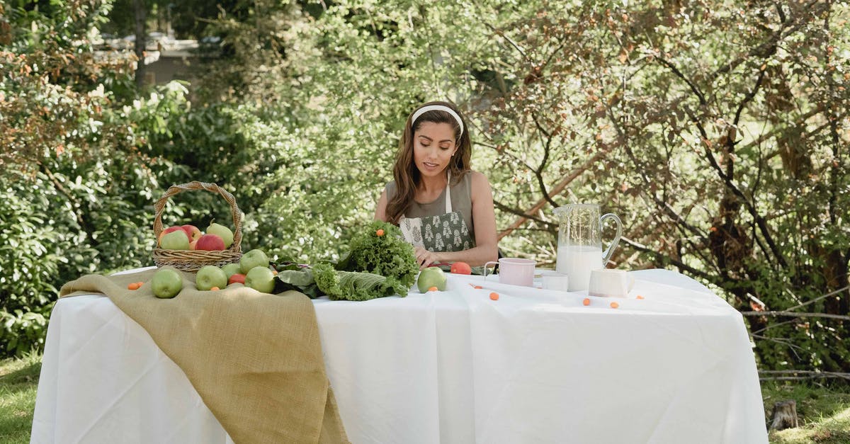 Tug could be milk and vodka? - Woman Sitting at a Table With Fresh Fruits and Vegetables