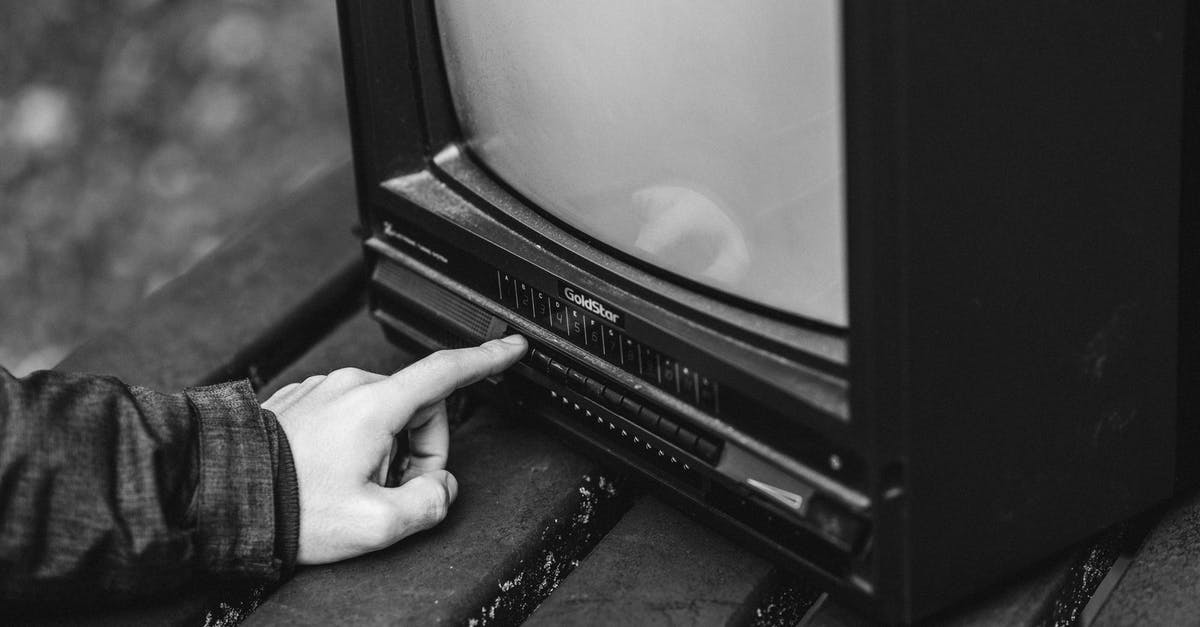 TV series about what a real man should be able to do on Discovery channel [closed] - Black and white of unrecognizable male pressing buttons on old fashioned television placed on wooden table in nature on blurred background