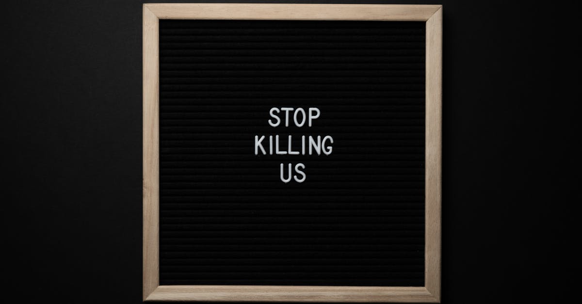 Vito killing Don Fanucci - Top view of slogan Stop Killing Us on surface of square blackboard on black background