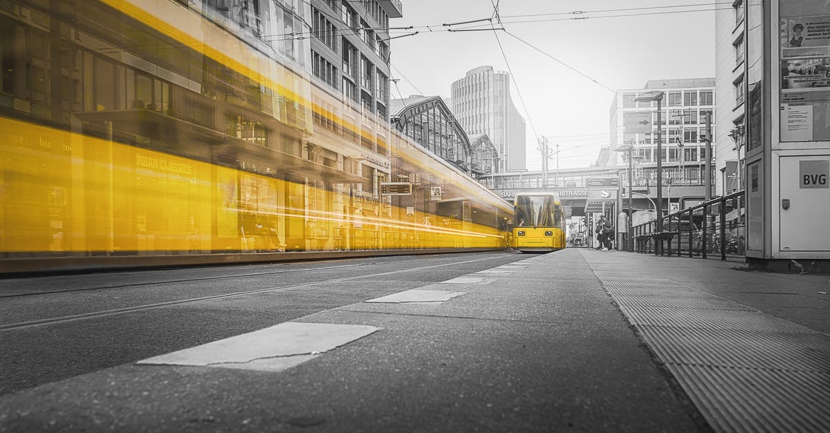 Was Berlin a part of the grand setup? - Selective Color Photography of Yellow Train Beside Building