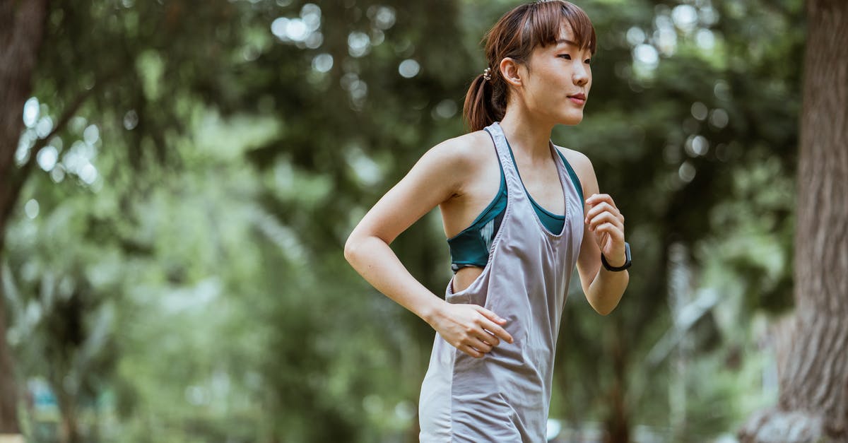 Was Chicken Run inspired by any specific movies? If so, which? - Side view of fit young Asian female jogger wearing gray sports top running along path in sunny summer park