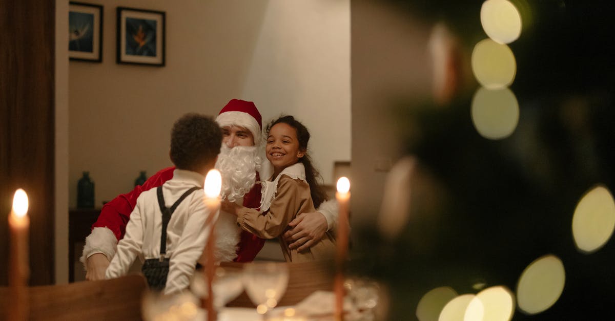 Was Kris Kringle really Santa? - Man and Woman Sitting on Chair in Front of Table With Candles