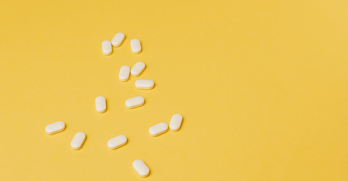 Was Rachel Zane talking about a poison pill? - From above of small white ellipse shaped pills of same size randomly placed on bright yellow background