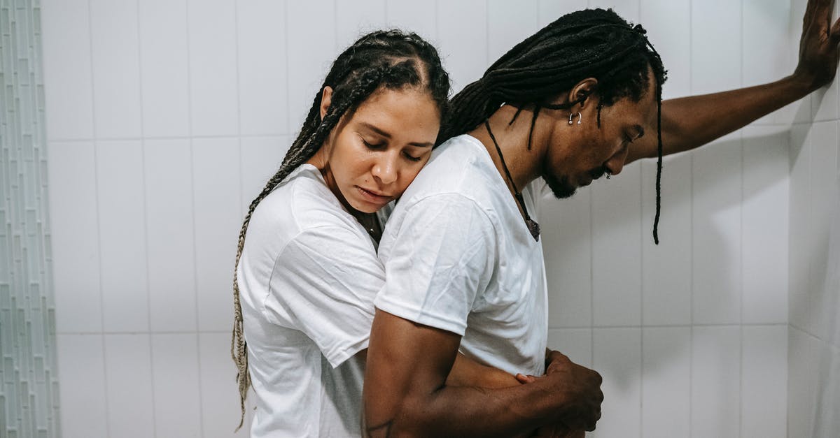 Was Steven Taylor contemplating the death of his wife before her affair was discovered? - Side view sad loving African American female in white shirt standing behind and embracing depressed unhappy husband in bathroom