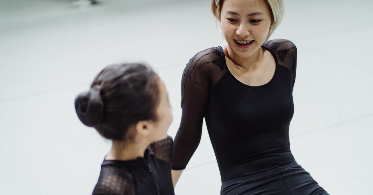 Was the other Ballerina a sparrow too? - Content fit female ballet dancer and girl in leotards sitting on floor in ballet school and discussing movement techniques