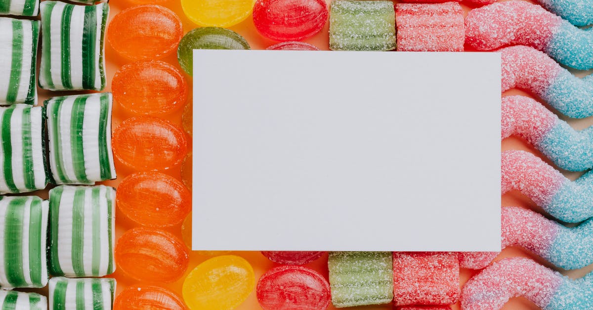 Was the typo in Paul Allen's busines card ever explained? - Top view closeup of blank paper card placed on multicolored various shapes yummy candies in light confectionery