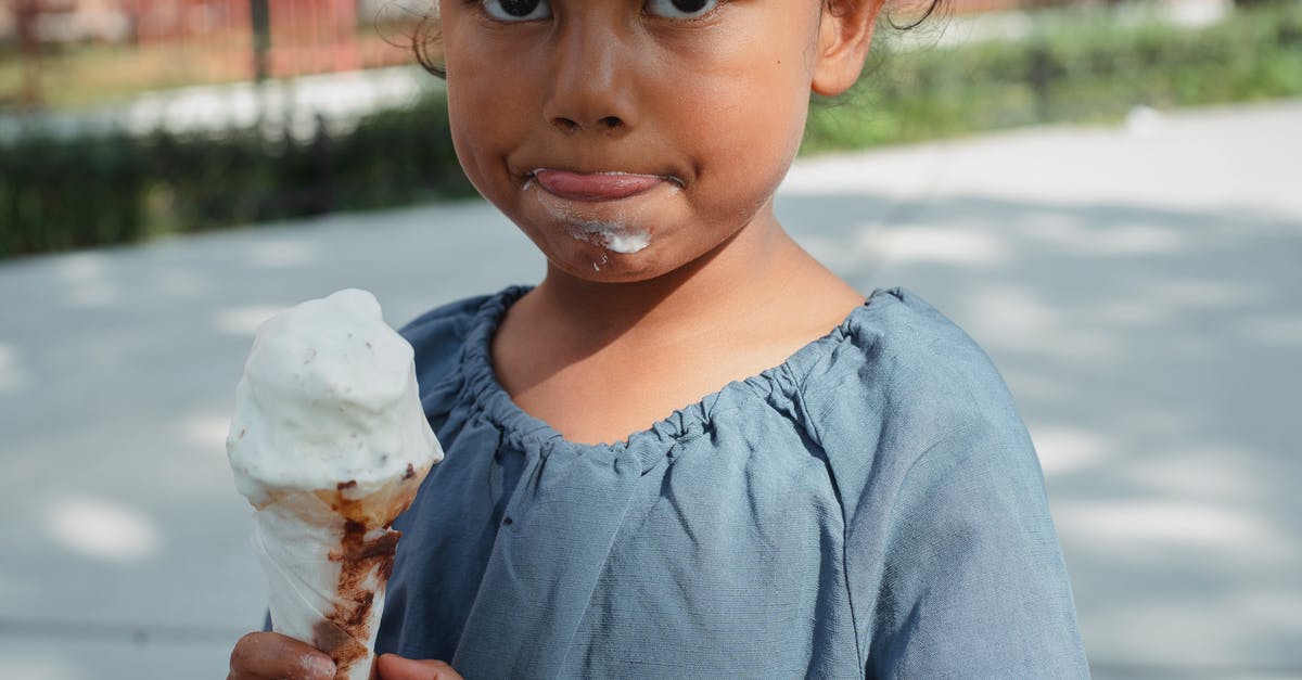 Was there a specific meaning behind each child in Willy Wonka and the Chocolate Factory? - Crop adorable little Asian girl in casual clothes eating ice cream and looking at camera