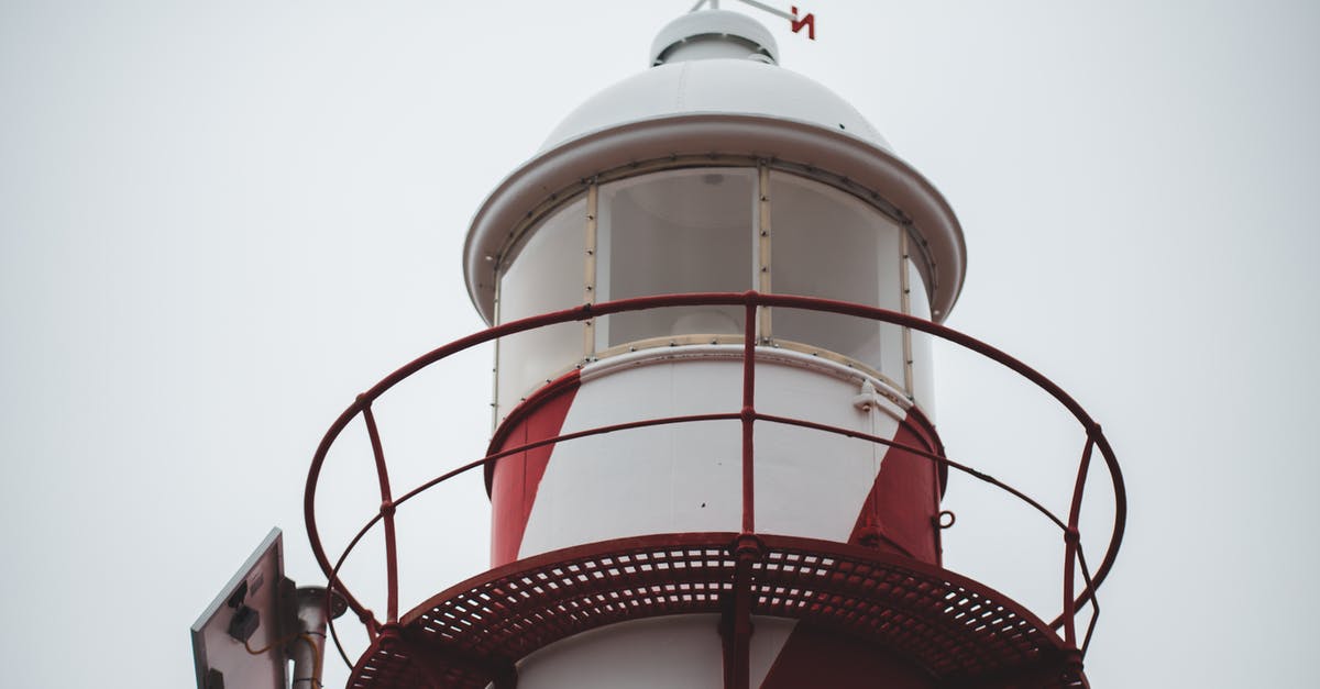 Water coming out of Teddys toy-gun in the lighthouse scene - Low angle of white and red lighthouse tower with windrose on domed roof against overcast sky