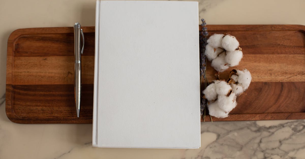 Were the origins of the List ever explained? - Overhead view of composition of empty hardcover book lying between metallic pen and soft cotton flowers on wooden tray with recesses