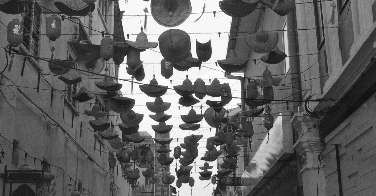 Western Parody - White hats vs Black hats [closed] - Grayscale Photo of Hanging Hats on the Street