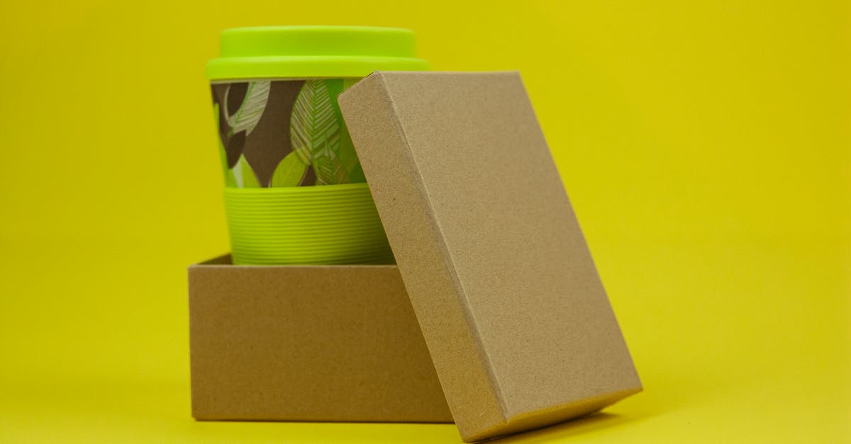 What's going on with Laurits and his new "pet"? - Reusable eco green bamboo cup with leaves in carton box on yellow background in light studio