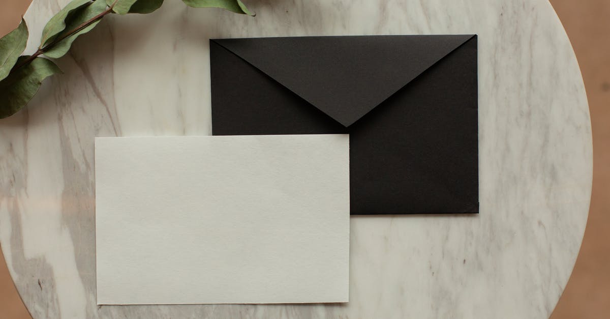 What's in the "Letters from Sophie" envelope? - Top view of blank black envelope with white card placed on table with pencil and dry green sprig in modern room