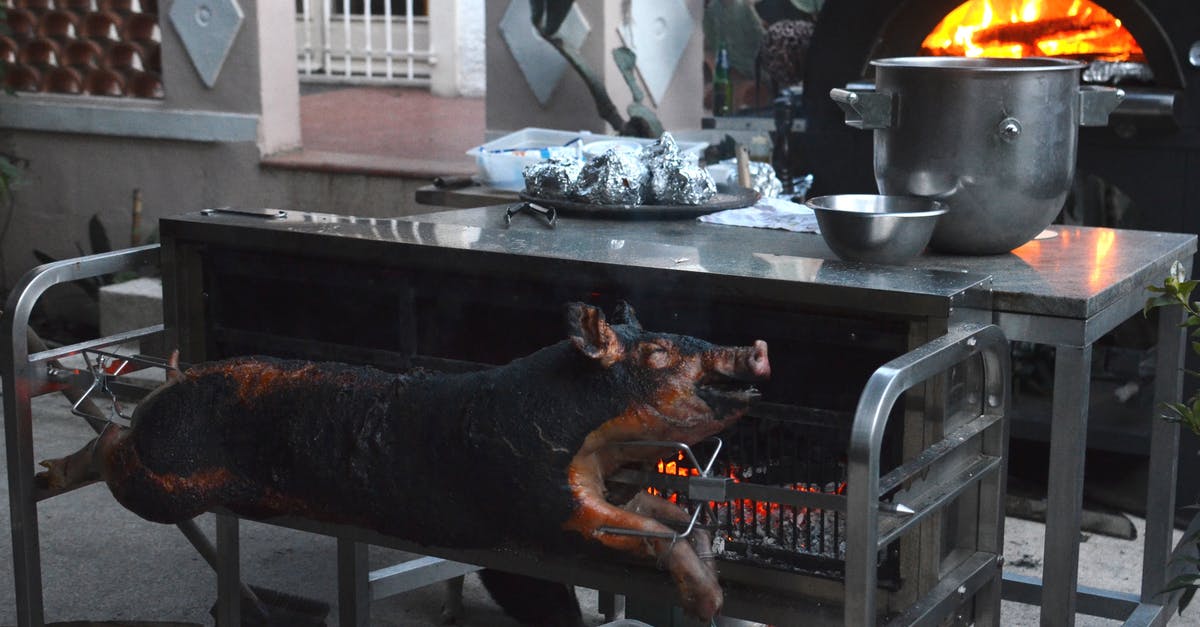 What's the production process for songs for Disney animated musicals? - Whole smoked pig on broach near metal table with various utensils in yard of countryside house