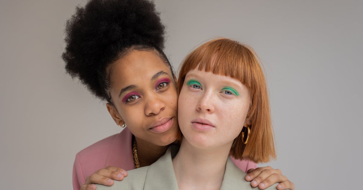 What's the proper term for individual TV episodes that feature multiple episodic storylines? - Gentle black woman with pink eyeshadows embracing red haired female from behind and looking at camera against gray background