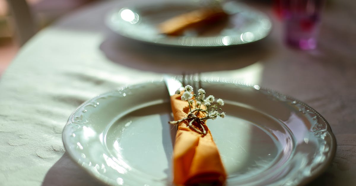 What's the significance or symbolism of the trinket tied with an orange string to the backpack? - Table serving with plate and cutlery decorated with fresh flowers