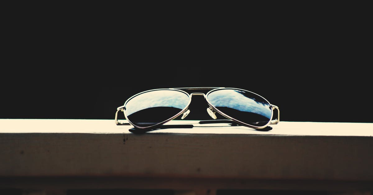 What's with the porch lights? - Black Lens Aviator-style Sunglasses With Gray Frames on Brown Wooden Railings