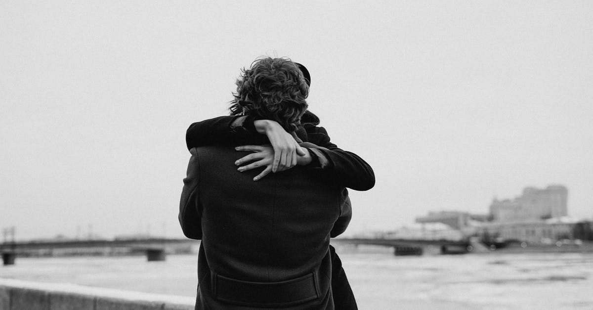 What all was on Max's back? - Grayscale Photo of Man Wearing Black Coat Hugging His Woman