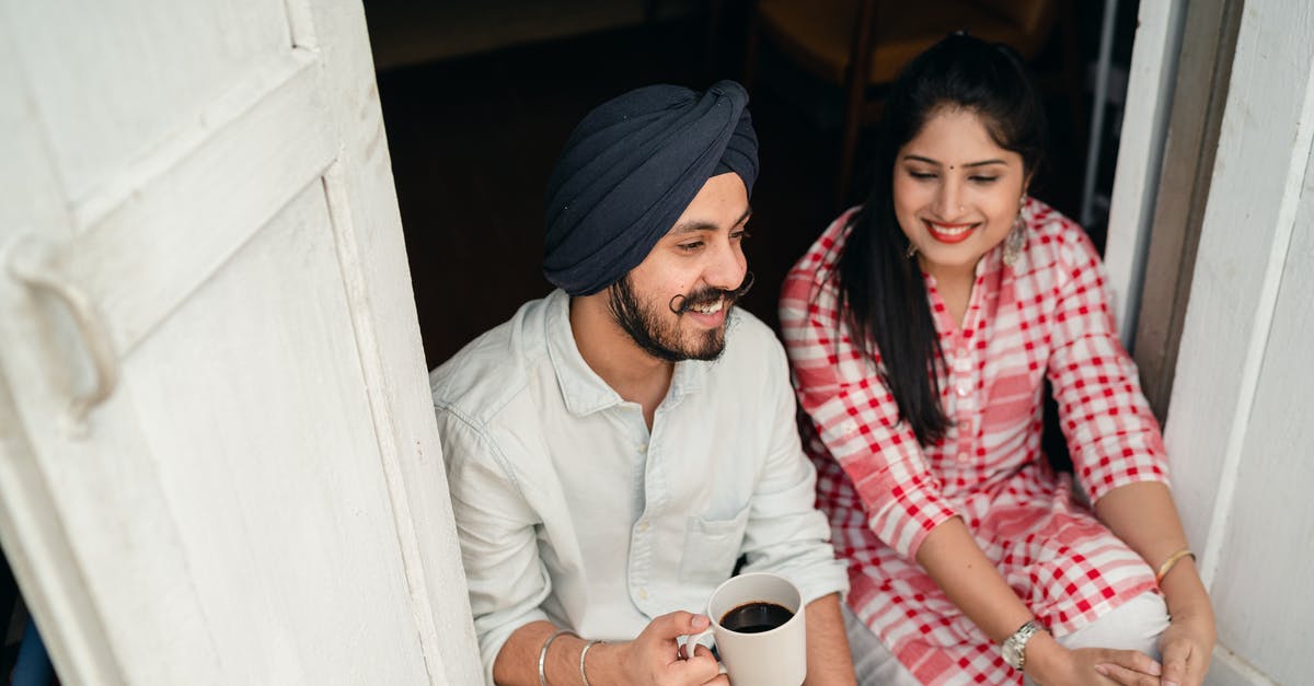 What are all the tie-ins and spin-offs from Cheers? - From above of smiling young Indian man with black coffee and woman in bright checkered shirt having pleasant conversation while sitting at threshold