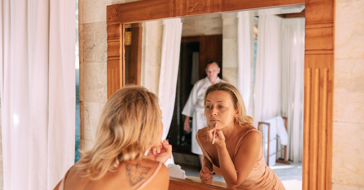 What are the Deviants doing on Earth? - Woman Looking in Mirror in Bathroom Doing Makeup