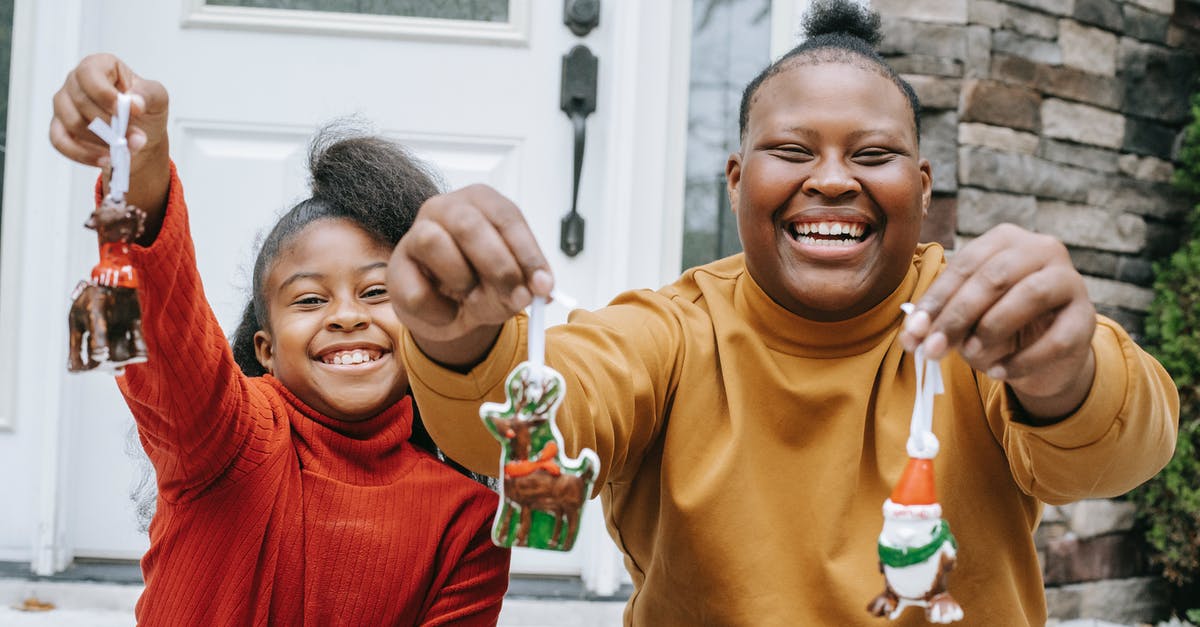 What are the Ghost of Christmas Present's Brothers? - Cheerful smiling black teens demonstrating Christmas decorations