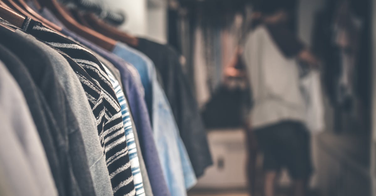 What are those items hanging behind the shop keeper? [closed] - Shallow Focus Photography of Clothes