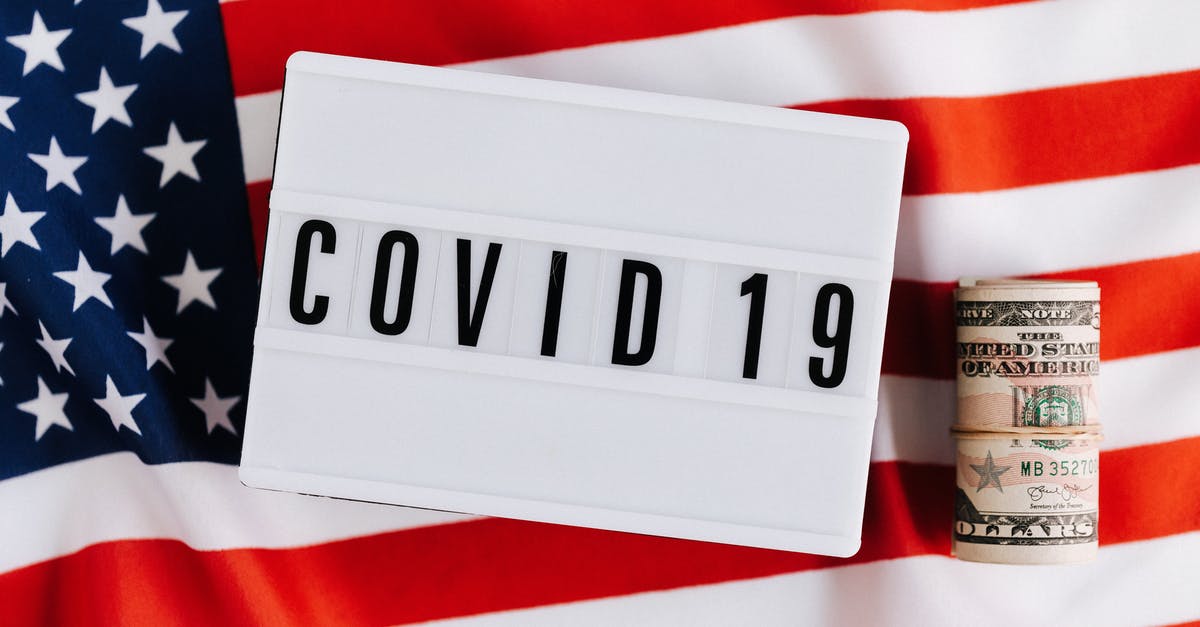 What causes a high budget title to be direct-to-DVD? - From above of plastic signboard with COVID 19 inscription on flag of USA and roll of paper money during financial crisis
