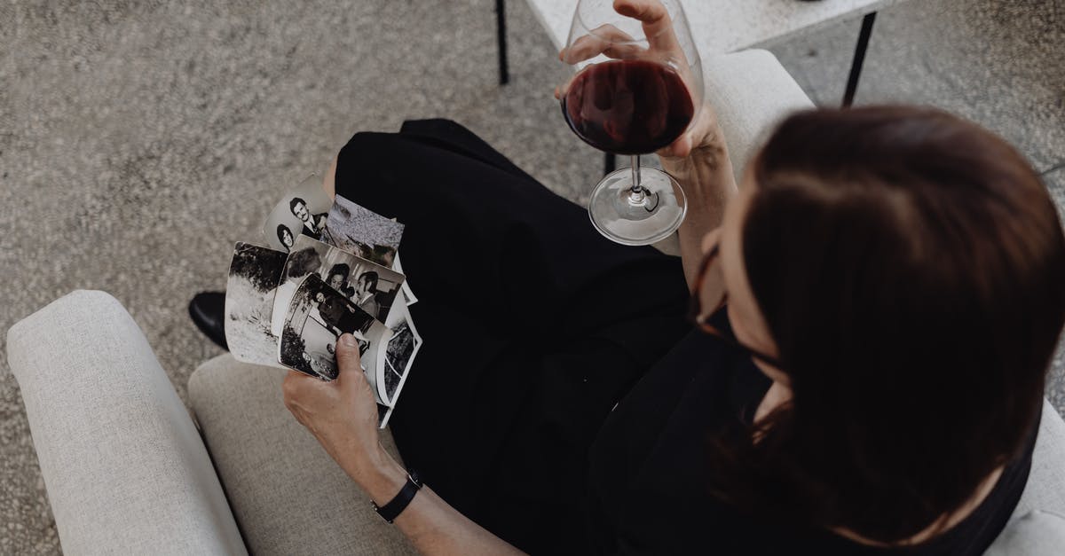 What death scenes do these pictures belong to? - Top View of a Woman Holding Pictures and Wine 