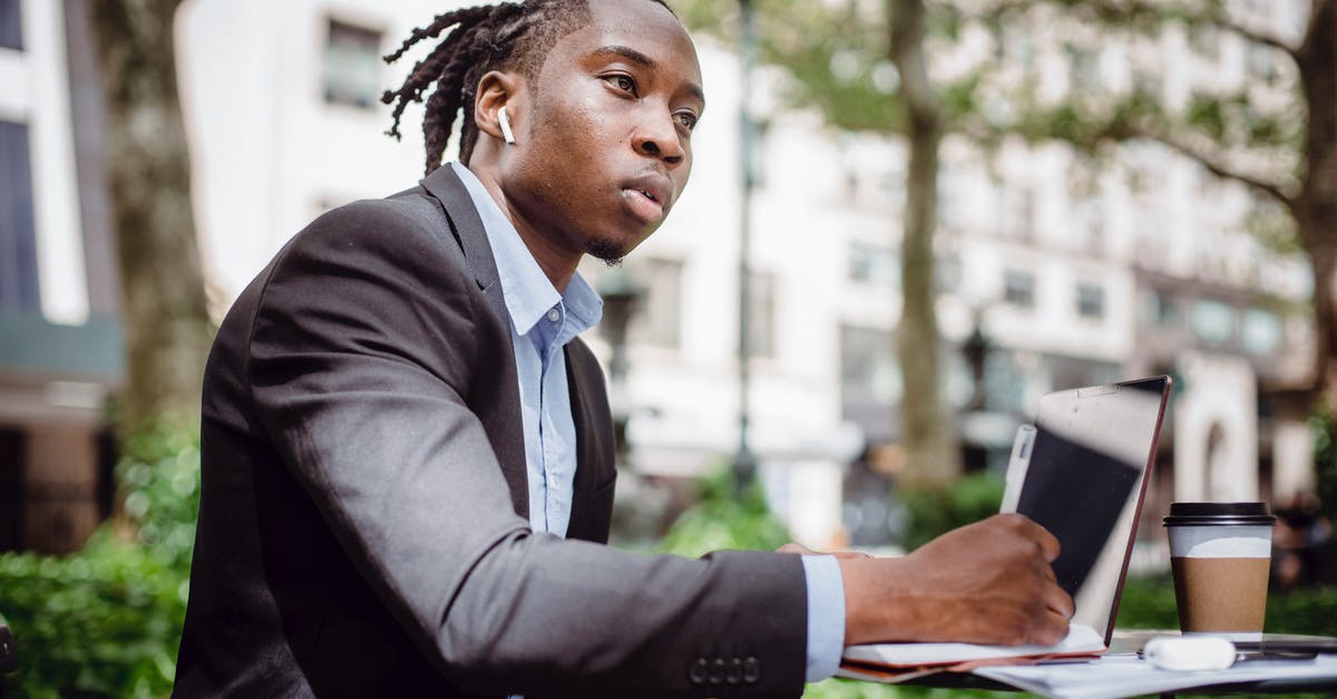 What did Muir think was going to happen after he left McLean? - Side view of young black male writer in suit and true wireless earphones looking away and thinking while taking notes in planner sitting in street cafe with laptop and coffee